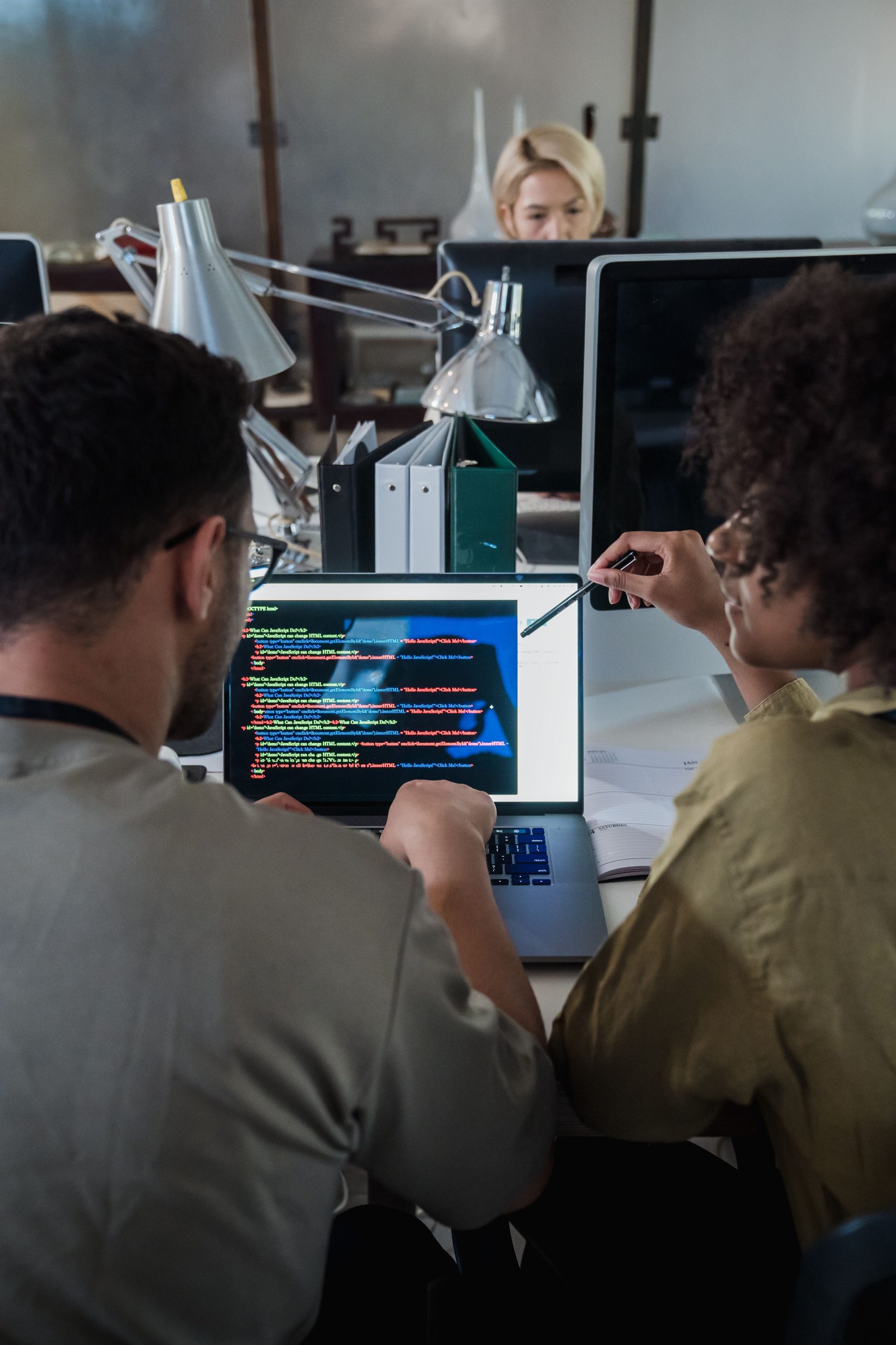 Software developers discussing code together